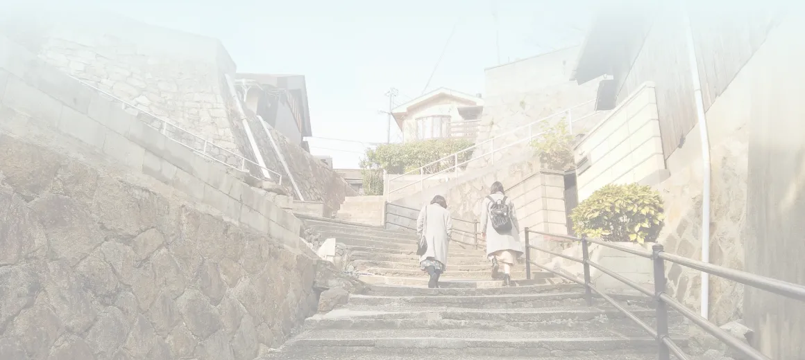 背景画像:女性2人が階段を登っています。